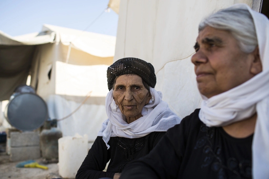 A Yezidi woman sits outside the tent where she lives in Shariya IDP camp outside Duhok.