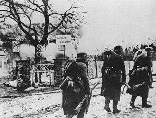 German troops pass through a village during the invasion...