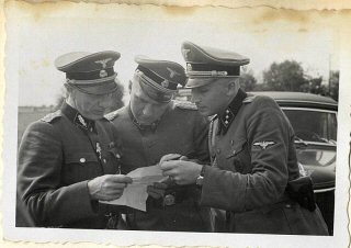 Richard Baer y Karl Höcker miran un documento con SS-Standartenführer...
