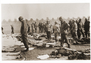 American soldiers view the bodies of prisoners laid...