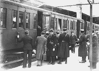 Jewish deportees, guarded by French police, board a...