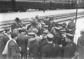 A group of Jewish men on a train platform with French...