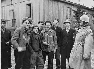 A US army officer (far right) poses with survivors...