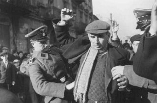 Homens da SS revistam judeus à procura de armas. Varsóvia...