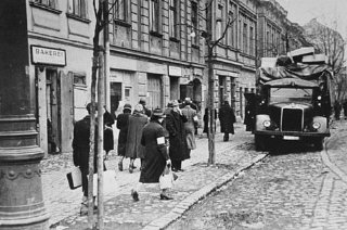 Des habitants du ghetto de Cracovie passent à côté...