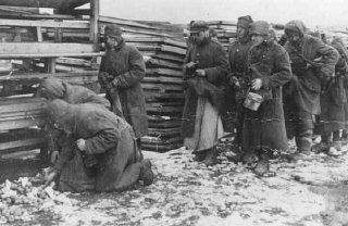 Soviet prisoners of war pause for rations during forced...