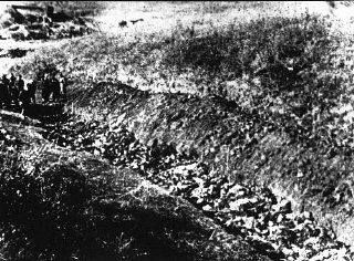 Soviet investigators (at left) view an opened grave...