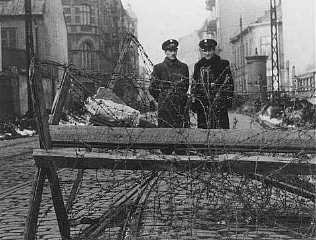 Jewish police at a barricaded entrance to the Warsaw...