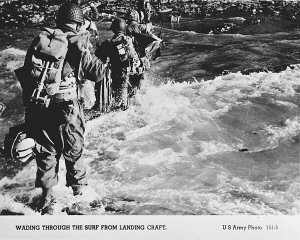 American troops wade through the surf on their arrival...
