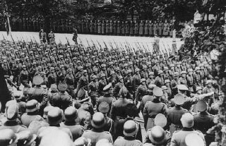 Adolf Hitler (lower right) gives Nazi salute as he...