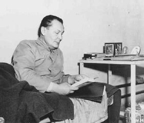 Defendant Herman Goering reads in his prison bunk at...