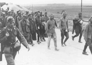 German soldiers guard Soviet prisoners of war marching...