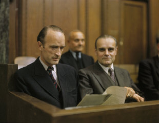 Defendant Alfried Krupp (left) reads a document while...
