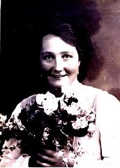 Formal portrait of Frieda Greinegger holding a bouquet...