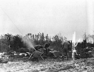 Mortar men of the 754th Tank Battalion fire an 81mm...