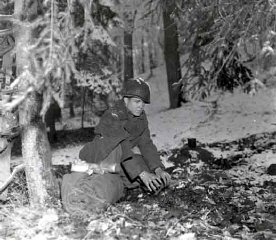 A soldier prepares to bed down for the night in a Belgian...