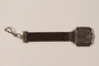Decorative metal piece attached to a short leather strap with a clip