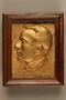 Framed, gold-colored plaque depicting a Jewish Hungarian banker