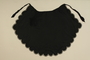 Scallop-edged black half apron worn by a Roma woman